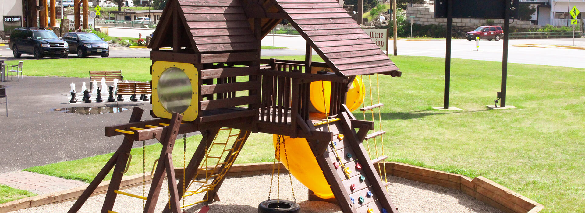 Photo of the exterior of Grapes and Grind with an outdoor childrens play area and an giant chess board. 